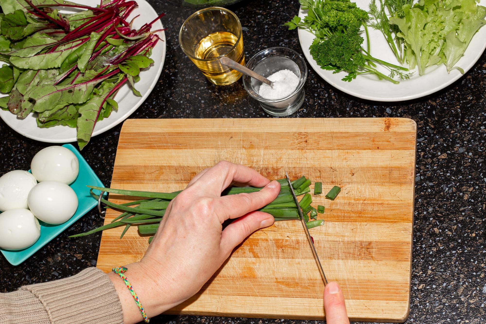hands arranging herbs on a wooden board